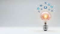 Light bulb with glowing brain and floating digital icons representing innovation, creativity, artificial intelligence and technology solutions.