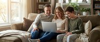 Happy Caucasian family with teenage son using laptop together on living room sofa, bonding over technology in cozy home interior with natural lighting.