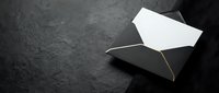 Elegant black envelope with white card on dark textured surface for luxury branding and premium correspondence design.
