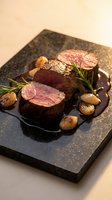 Grilled beef tenderloin medallions with rosemary and mushrooms on slate board, gourmet restaurant presentation for fine dining menu and culinary photography.