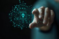 Hand touching glowing turquoise arrow icon surrounded by digital particles, representing business growth and technological advancement on dark background.