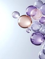Transparent bubbles in purple and rose gold tones floating on light background create elegant composition for luxury cosmetic and beauty product advertising.