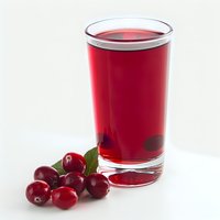 Fresh cranberry juice in clear glass with ripe berries and green leaf on white background, healthy antioxidant beverage for natural detox and wellness.