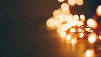 Warm golden string lights creating soft bokeh effect on dark background for cozy holiday atmosphere and festive home decoration projects.