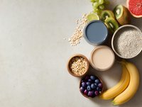 Healthy breakfast ingredients with fresh fruits, smoothies, oats, and chia seeds on light background for nutrition and diet concepts.