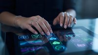 Businesswoman hands touching digital tablet screen with glowing technology icons and interface elements for modern workplace productivity solutions.