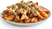 Crispy potato wedges topped with creamy sauce, herbs and spices on gray plate. Golden brown roasted potatoes garnished with fresh parsley and black pepper.