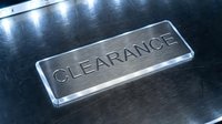 Metallic clearance sign with engraved text on brushed stainless steel surface, glowing edges, industrial style for retail, sale, and discount concepts.