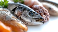 Fresh raw fish and seafood composition with salmon, trout head and tentacles on rustic wooden background, macro food photography for restaurant menu.