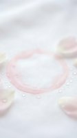 Close-up of contact lens with water droplets on white surface, showcasing optical care products for vision correction and eye health applications.