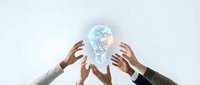 Multiple diverse hands reaching toward a glowing digital light bulb, symbolizing teamwork, innovation, and shared creative vision in business.