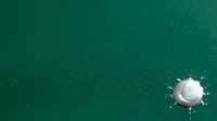 Aerial view of a solitary sailboat on turquoise water, ideal for travel, vacation, and nautical design projects.