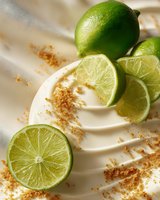 Fresh lime slices and whole fruit on creamy dessert with sprinkled spice, creating vibrant contrast for culinary photography.