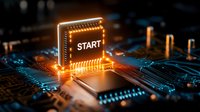 Glowing START button on computer circuit board with orange light effects, representing technology initialization or system boot process.
