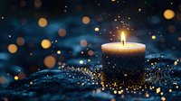 Glowing candle with golden bokeh lights on dark blue background creates magical atmosphere. Scattered glitter adds sparkle and dreamy ambiance.