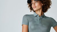 Young mixed race woman with curly hair wearing sage green polo shirt and black cap against light background, fashion portrait in minimalist style.