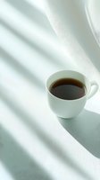 White cup of tea on minimalist background with soft window shadows creating serene morning atmosphere.