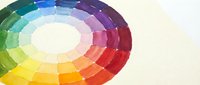 Watercolor color wheel with vibrant rainbow hues arranged in circular spectrum on white paper background for art education and design projects.