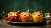 Colorful stuffed bell peppers with quinoa and herbs on rustic plate, warm candlelight creating cozy dinner atmosphere for healthy meal preparation.