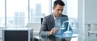 Professional businessman in gray suit interacting with holographic justice scales in modern office, representing legal technology and digital law services.