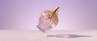 Elegant glass perfume bottle with golden cap floating above marble surface against soft purple gradient background for luxury cosmetics branding.