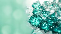 Translucent turquoise crystal chunks with sharp facets scattered on soft mint background, suitable for luxury, wellness, and cosmetic product design applications.