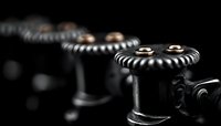 Vintage mechanical gears in dramatic lighting with selective focus on metal cog wheels against dark background, showcasing industrial machinery details.