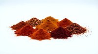 Colorful spice powder piles with paprika, chili, turmeric and pepper seeds isolated on white background for culinary cooking and seasoning recipes.