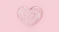 Pink heart-shaped cream or lotion swirl on soft pink background for skincare, cosmetics and beauty product design concepts.