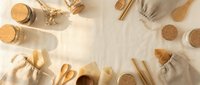 Zero waste lifestyle flat lay with eco-friendly reusable items, linen bags, cork jars, wooden utensils, and bamboo straws on a light background.