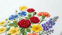 Embroidered floral arrangement featuring colorful roses, daisies, and lavender on white fabric. Handmade needlework design for textile art and craft projects.