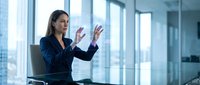 Professional businesswoman presenting strategy in modern corporate boardroom with city skyline view through large windows for business presentations.