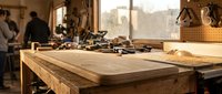 Traditional woodworking workshop with vintage hand tools on rustic wooden workbench. Craftsman workspace for furniture making and carpentry projects.
