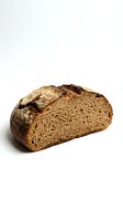 Freshly baked whole wheat bread loaf with crusty exterior and airy crumb structure, isolated on white background for bakery, food, and culinary uses.