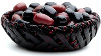 Black woven basket filled with shiny red and black decorative spheres, isolated on white background for design projects, home decor concepts, and retail displays.