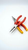 Professional needle nose pliers with red and yellow ergonomic handles isolated on white background for workshop and electrical repair projects.