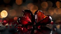 Broken red glass heart on dark reflective surface with bokeh lights background creates romantic yet dramatic mood for Valentine's Day or heartbreak themes.