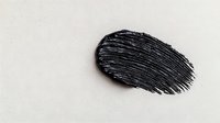 Black mascara smear or brush stroke on white background, showing cosmetic texture and application. Isolated makeup product swatch for beauty and cosmetics design.