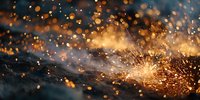 Bright sparks and golden embers flying from metal grinding or welding process against dark background, creating dramatic industrial atmosphere.