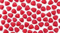 Fresh raspberries scattered on white background, isolated berries ready for food, nutrition, and healthy eating design projects.