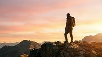 Hiker with backpack standing on mountain peak at sunset, enjoying panoramic views of alpine landscape and golden sky during outdoor adventure and trekking expedition.