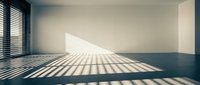 Empty modern room with sunlight streaming through venetian blinds creating dramatic shadow patterns on white walls and dark floor for interior design.