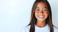 Young Asian woman with bright genuine smile wearing white t-shirt against light background, radiating positivity and confidence in casual studio portrait.