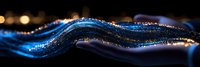 Abstract glowing blue wave with golden sparkles and light particles flowing on dark background creates magical atmosphere for luxury design projects.
