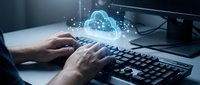 Hands typing on keyboard with glowing cloud computing hologram displaying network connections and data transfer for modern business technology solutions.