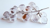 Glass grape cluster with delicate transparent spheres on silver branch against white background, artistic modern home decor element.