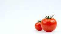 Fresh red tomatoes with water droplets isolated on white background for healthy cooking and organic food concepts.