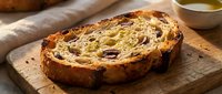 Sliced panettone with raisins and dried fruit on wooden board next to cup of tea, ideal for bakery, food, and holiday culinary content.