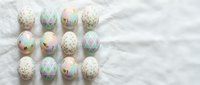 Pastel decorated Easter eggs with gold foil patterns arranged on white marble background for spring holiday celebration and festive seasonal design.