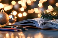 Open book with colored pencils against festive Christmas lights and ornaments background, creating cozy holiday atmosphere with soft bokeh effect.